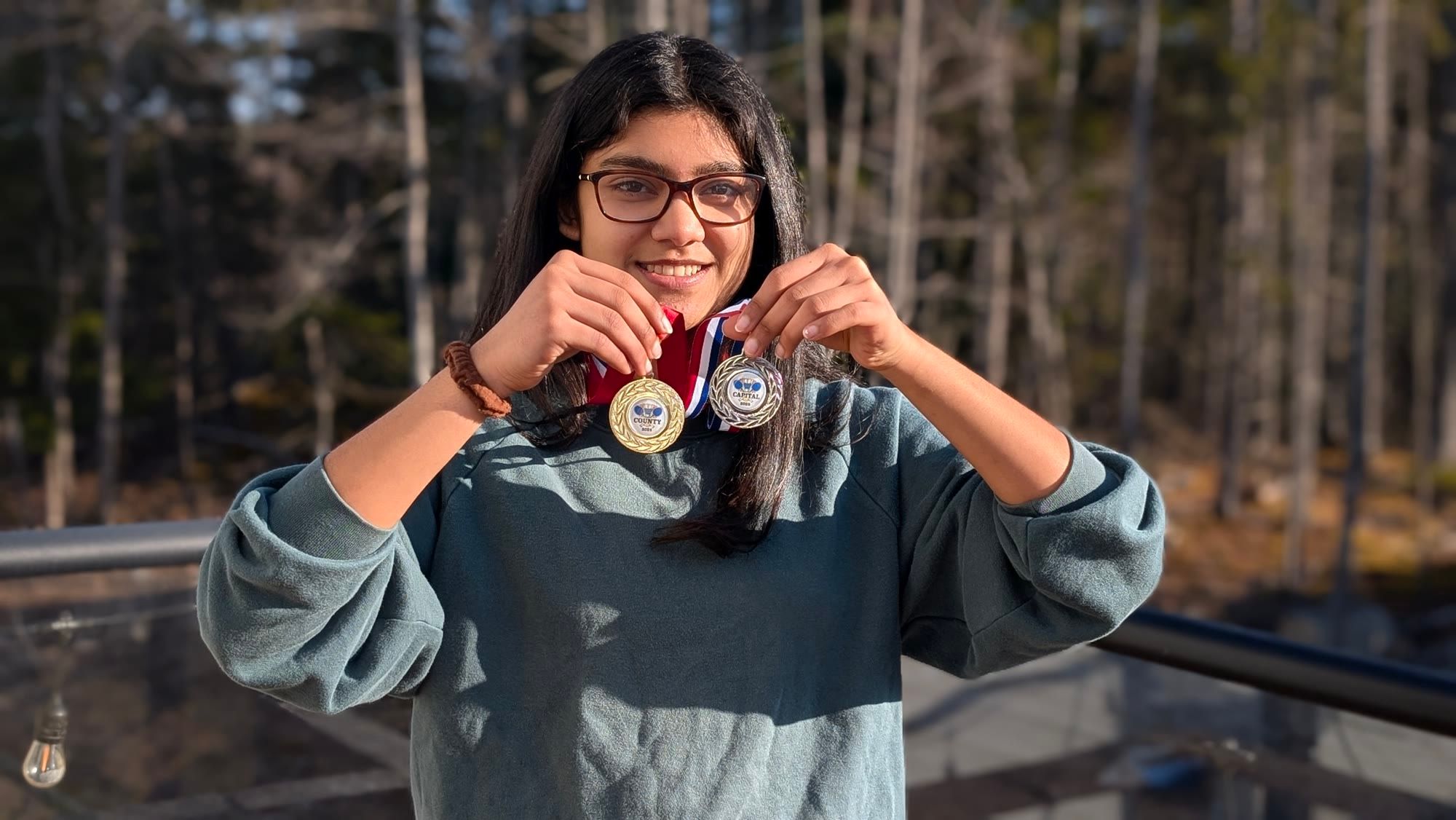 Shreyasi Paul smiling and holding two medals